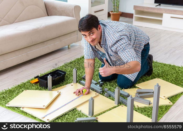 The man assembling furniture at home. Man assembling furniture at home