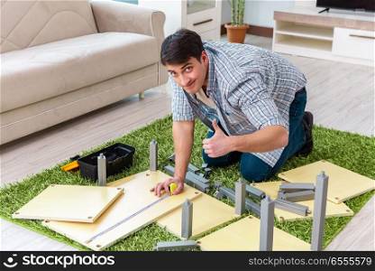 The man assembling furniture at home. Man assembling furniture at home