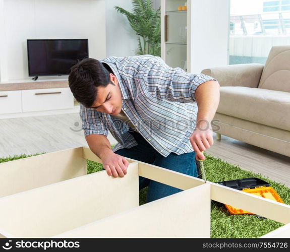 The man assembling furniture at home. Man assembling furniture at home