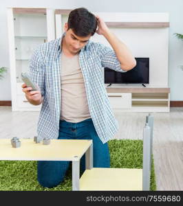 The man assembling furniture at home. Man assembling furniture at home