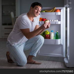 The man at the fridge eating at night. Man at the fridge eating at night