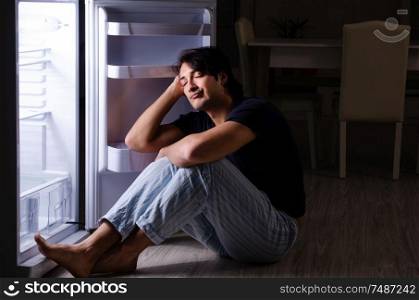 The man breaking diet at night near fridge. Man breaking diet at night near fridge