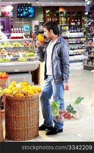 The man chooses a grapefruit in shop