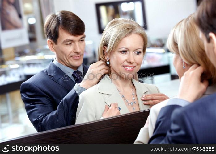 The man clasps a jeweller necklace to the woman