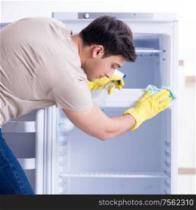 The man cleaning fridge in hygiene concept. Man cleaning fridge in hygiene concept