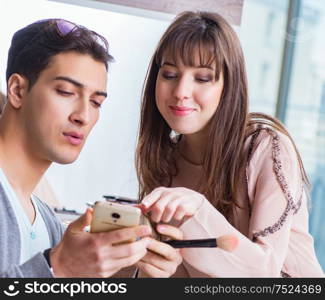 The man doing make-up for cute woman in beauty salon. Man doing make-up for cute woman in beauty salon