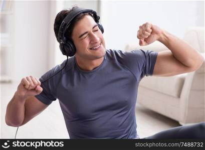 The man doing sports at home and listening to music. Man doing sports at home and listening to music