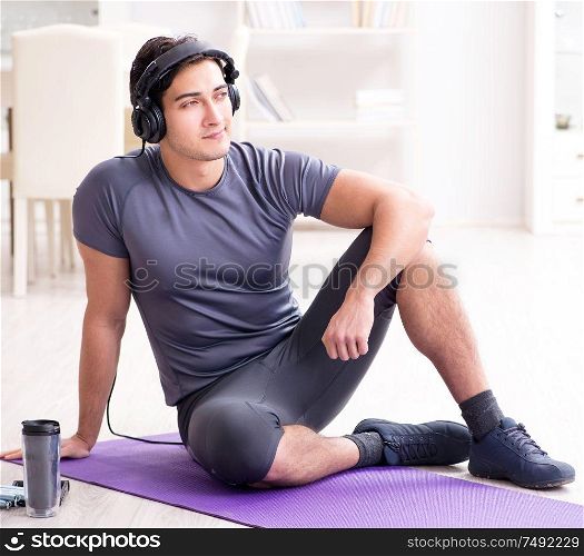 The man doing sports at home and listening to music. Man doing sports at home and listening to music