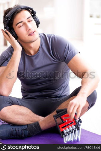 The man doing sports with resistance band and listening to music. Man doing sports with resistance band and listening to music