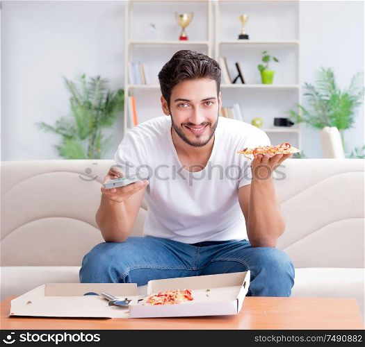 The man eating pizza having a takeaway at home relaxing resting. Man eating pizza having a takeaway at home relaxing resting