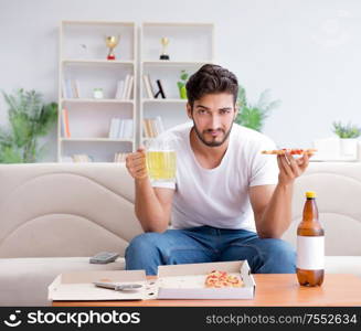 The man eating pizza having a takeaway at home relaxing resting. Man eating pizza having a takeaway at home relaxing resting