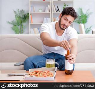 The man eating pizza having a takeaway at home relaxing resting. Man eating pizza having a takeaway at home relaxing resting