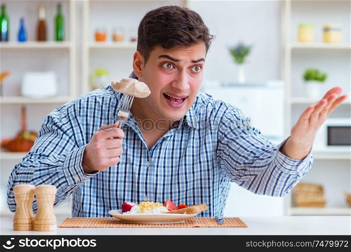 The man eating tasteless food at home for lunch. Man eating tasteless food at home for lunch