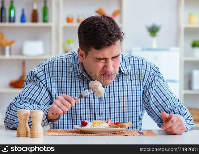 The man eating tasteless food at home for lunch. Man eating tasteless food at home for lunch