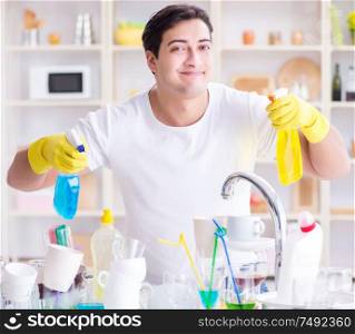 The man enjoying dish washing chores at home. Man enjoying dish washing chores at home
