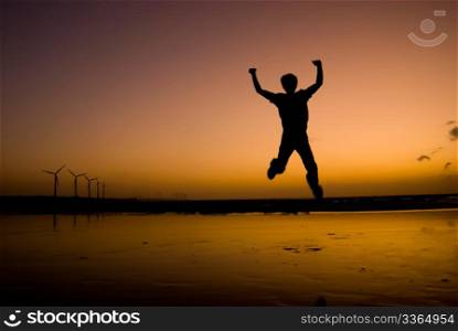 The man excited Jump on the beach under sunset, success concept.