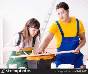The man explaining woman woodworking tips in wood workshop. Man explaining woman woodworking tips in wood workshop