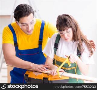 The man explaining woman woodworking tips in wood workshop. Man explaining woman woodworking tips in wood workshop