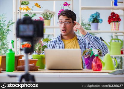 The man florist gardener vlogger blogger shooting video on camera. Man florist gardener vlogger blogger shooting video on camera