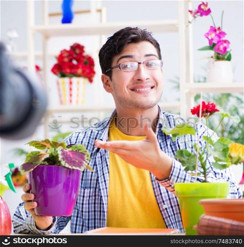 The man florist gardener vlogger blogger shooting video on camera. Man florist gardener vlogger blogger shooting video on camera