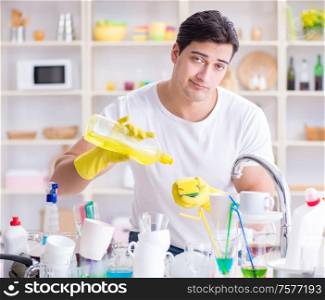 The man frustrated at having to wash dishes. Man frustrated at having to wash dishes