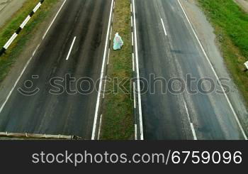 The man goes on dividing line of the road, shooting from above