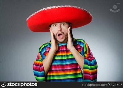 The man in a vivid mexican poncho gray background isolated. Man in a vivid mexican poncho gray background isolated