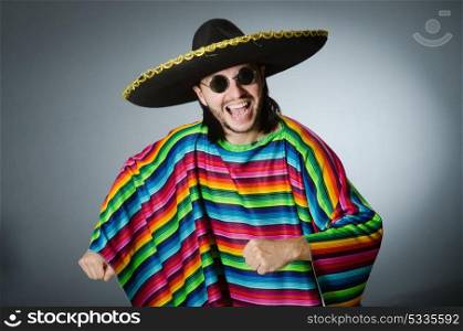 The man in a vivid mexican poncho gray background isolated. Man in a vivid mexican poncho gray background isolated