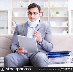 The man in neck brace cervical collar working from home teleworking. Man in neck brace cervical collar working from home teleworking