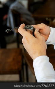 the man in the brown suit looks at his watch, hand clock