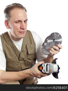 The man in working overalls with the detachable machine and saw disks