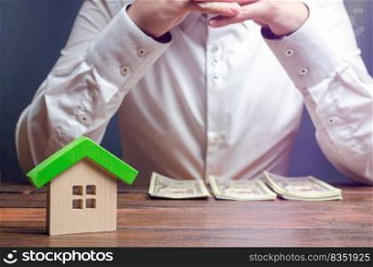 The man is sitting thinking over the sorted money. Expense planning and financial issues. Calculation of property tax, payment of utilities. Counting the costs of repairing or buying a new home.