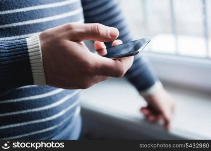 The man is using a smartphone. Modern mobile phone in hand.