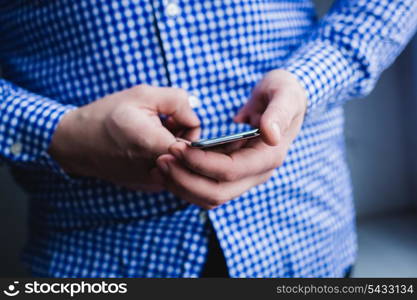 The man is using a smartphone. Modern mobile phone in hand.