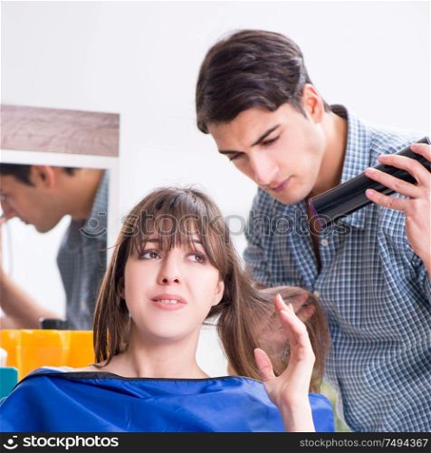The man male hairdresser doing haircut for woman. Man male hairdresser doing haircut for woman
