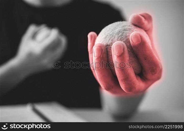 The man massages his finger by tennis balls. Office syndrome concept. Pain symptom area is shown with red color. Extreme close up shot. Black and white tone.