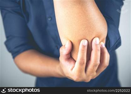 The man pains elbow. These symptoms may cause by sport, hard work with arm. Close up shot.