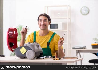 The man repairman repairing vacuum cleaner . Man repairman repairing vacuum cleaner 