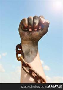 The man&rsquo;s hand is encased in an iron rusty chain against the sky