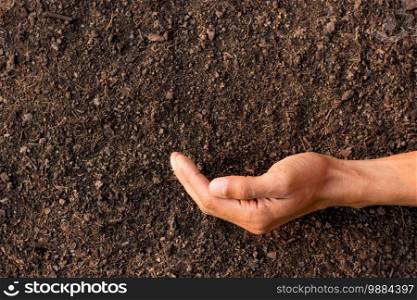 The man’s hands were placed on fertile soil suitable for cultivation.