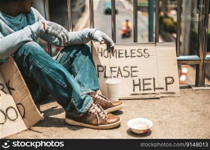 The man sitting begging on an overpass with messages homeless people please help and work well with food.
