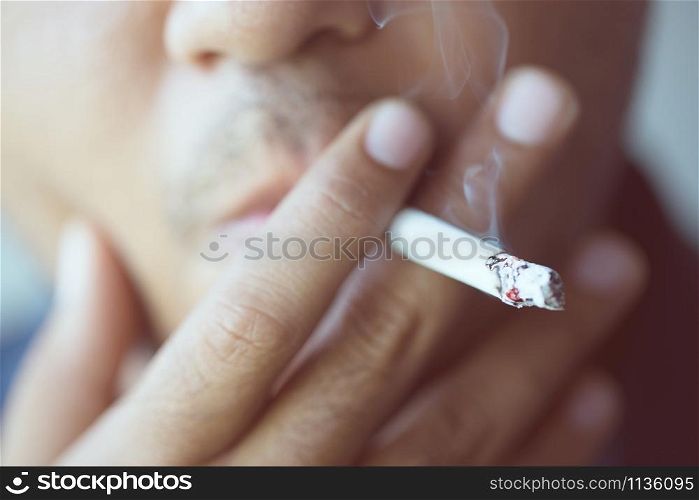 The man smoking a cigarette. Cigarette smoke spread.