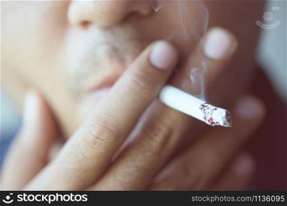 The man smoking a cigarette. Cigarette smoke spread.