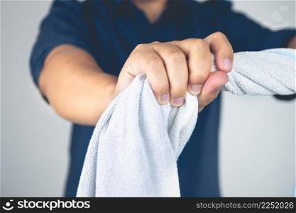 The man twists towel to massage and does physical therapy his arm. Elbow injury from tennis, golf, hard work. Healthcare knowledge. Medium close up shot.