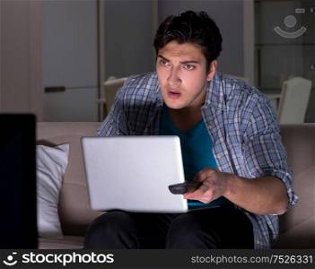 The man watching tv late at night. Man watching tv late at night