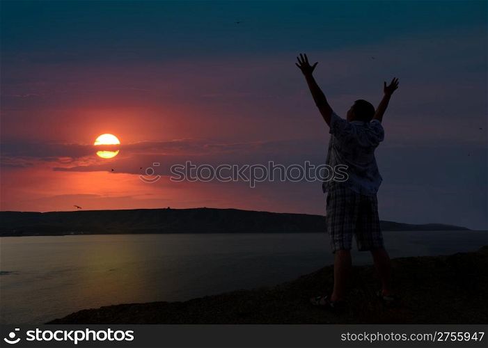The man welcomes the sunset sun. Upwards the lifted hands