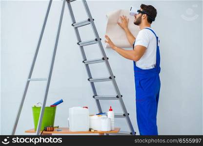The man with vr glasses gluing wallpaper. Man with VR glasses gluing wallpaper
