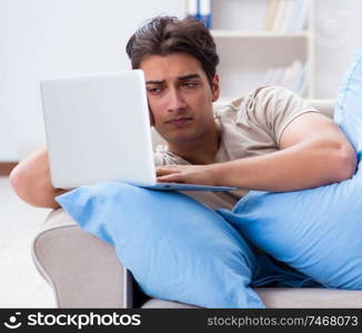 The man working late at his laptop at home. Man working late at his laptop at home