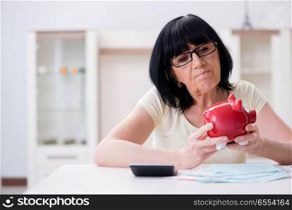 The mature woman trying to reconcile her bills. Mature woman trying to reconcile her bills