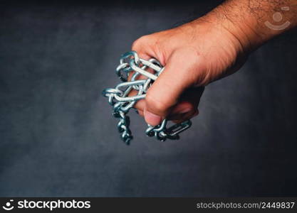 The mechanic carries a metal chain in his hand with a black color background